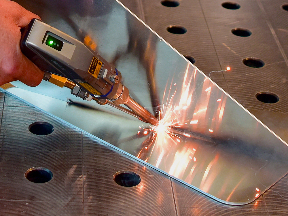 Employee operates hand-held laser welding machine